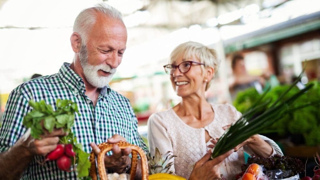 Senior couple shopping for fresh produce at a local market in The Shops at Marley Park.